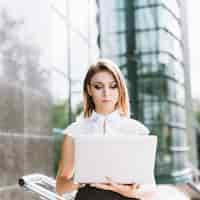 Free photo portrait of young businesswoman using laptop