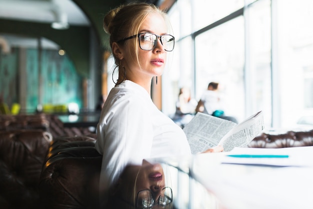 Portrait of a young businesswoman with newspaper