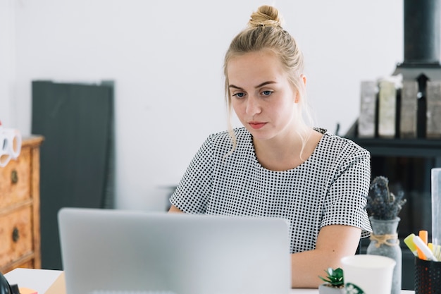 Portrait of a young businesswoman working on laptop in the office