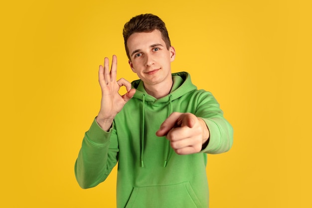 Portrait of young caucasian man isolated on yellow studio