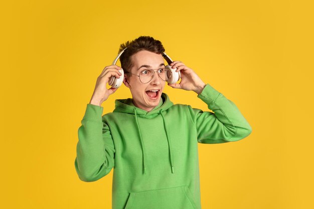 Portrait of young caucasian man isolated on yellow