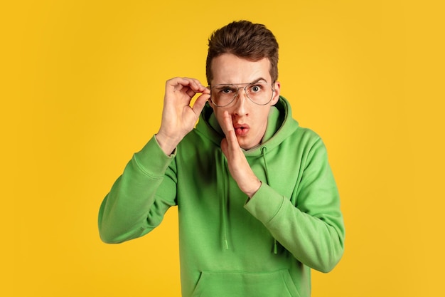 Portrait of young caucasian man isolated on yellow