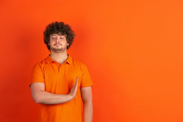 オレンジスタジオに明るい感情を持つ若い白人男の肖像