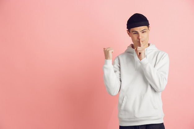 Portrait of young caucasian man with bright emotions on pink studio background