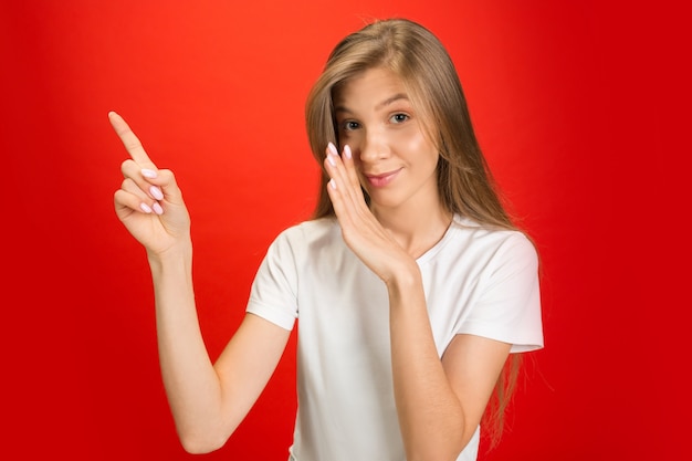 Portrait of young caucasian woman with bright emotions on red studio