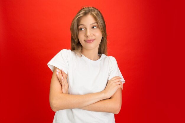 Portrait of young caucasian woman with bright emotions on red studio