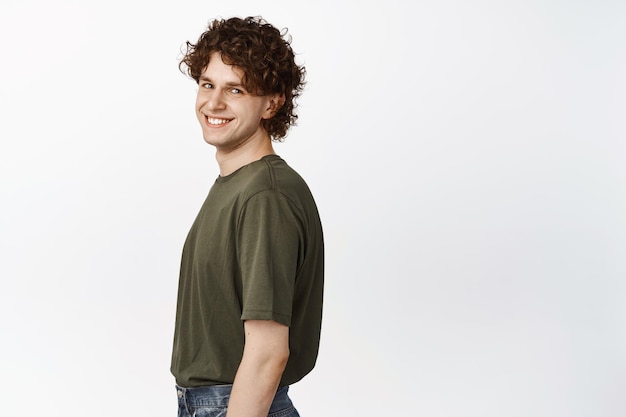 Portrait of young charismatic gay man with curly hair turn head at camera looking optimistic white background