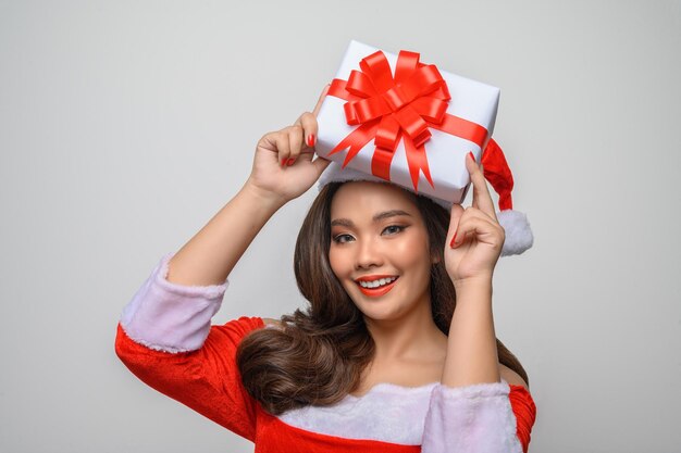 Portrait Young charming woman in santa costume holding large present box