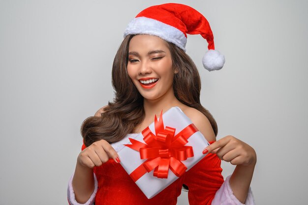 Portrait Young charming woman in santa costume holding present box