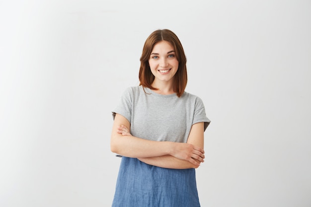 Portrait of young cheerful beautiful girl smiling with crossed arms .