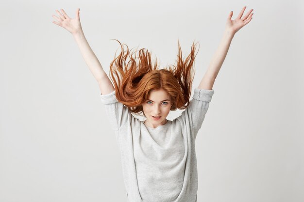 Portrait of young cheerful beautiful redhead girl smiling shaking hair .