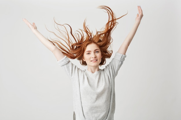 Foto gratuita ritratto dei capelli stringenti sorridenti della giovane bella ragazza allegra della testarossa.