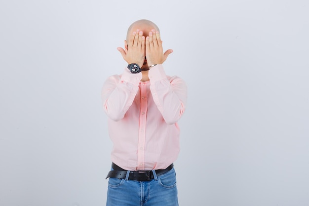 Portrait of a young cheerful man covering eyes