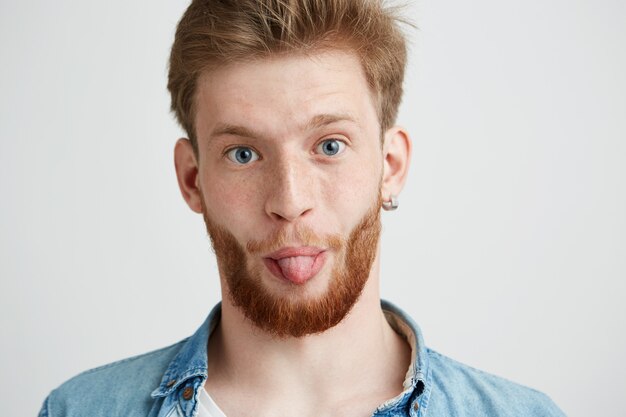 Portrait of young cheerful man showing tongue.