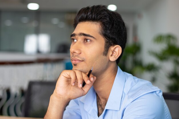 Портрет молодой концентрированный бизнесмен или студент в офисе