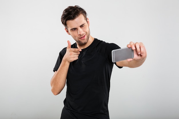 Portrait of a young confident man pointing finger