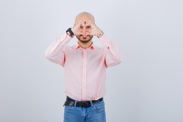 Portrait of a young confident man showing heart gesture