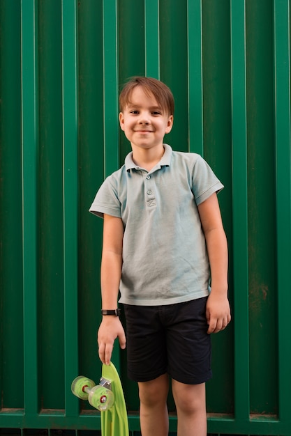 Portrait Young cool smiling BOY in blue polo posing with PENNY BOARD