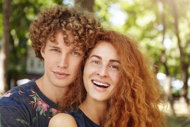 Free photo portrait of young couple hugging and looking at camera