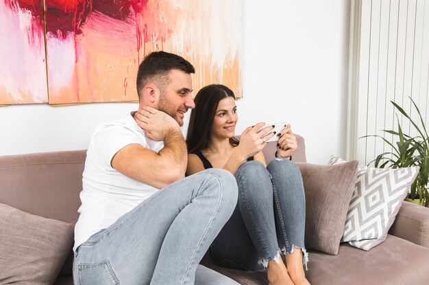 Portrait of a young couple sitting together on sofa