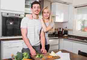 Free photo portrait of young couple standing in the kitchen