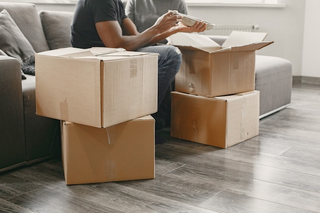 Portrait of young couple with cardboard boxes at new home, moving house concept.