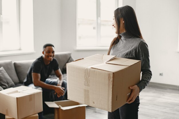 Portrait of young couple with cardboard boxes at new home, moving house concept.