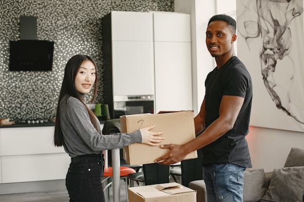 Free photo portrait of young couple with cardboard boxes at new home, moving house concept.