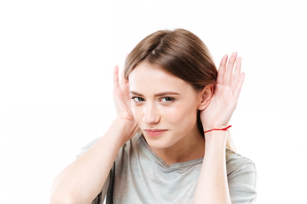 Portrait of a young curious young woman trying to hear rumors