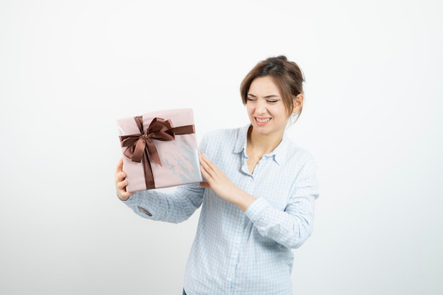 리본이 달린 선물 상자를 들고 있는 귀여운 소녀의 초상화. 고품질 사진