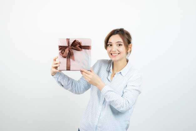 Free photo portrait of a young cute girl holding present box with ribbon. high quality photo