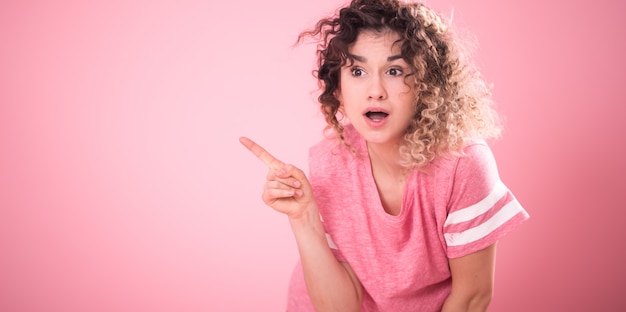 Portrait of young cute surprised girl with curly hair