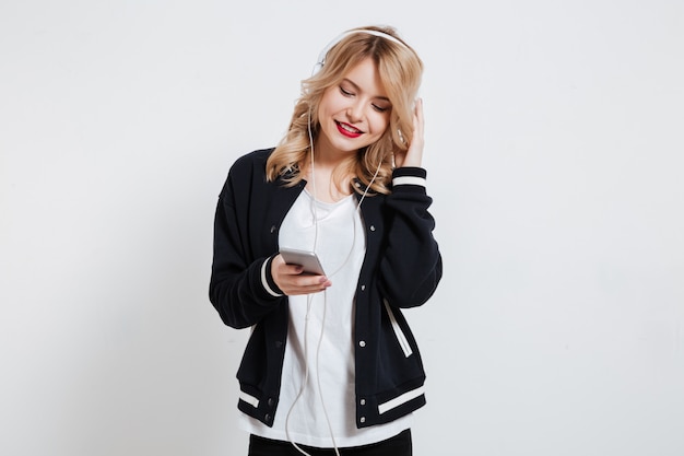 Portrait of young cute young woman listening to music with earphones