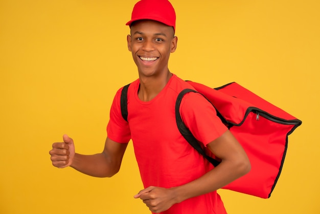 Portrait of a young delivery man showing thumb up.