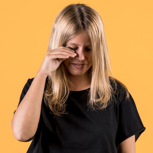 Free photo portrait of young disable woman crying on plain backdrop