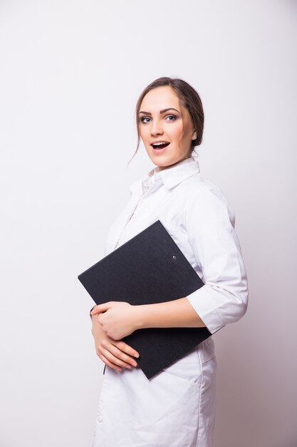 Portrait of young doctor or medic with clipboard and stethoscope isolated on white wall