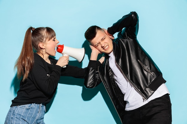 Portrait of young emotional female student with megaphone