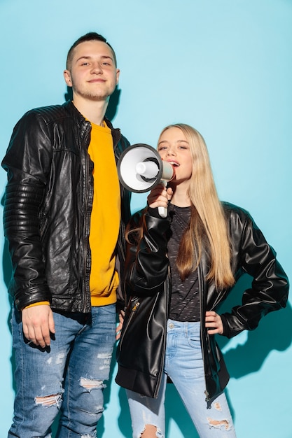 Portrait of young emotional female student with megaphone