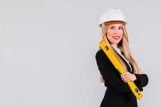 Portrait of a young female architect holding ruler in hand looking at camera