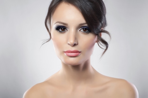 Portrait of young female beauty with long dark hair