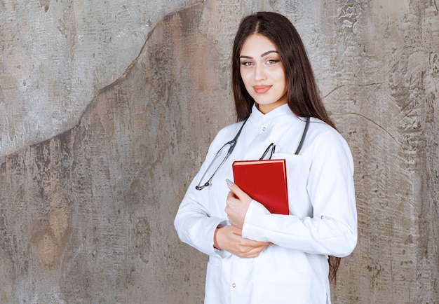 Portrait of young female doctor on rustic wall