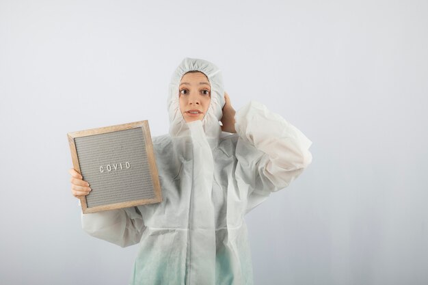 Portrait of young female doctor scientist wearing defensive lab coat. 