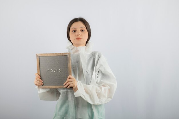 Portrait of young female doctor scientist wearing defensive lab coat. 