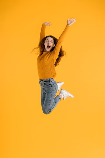 Бесплатное фото Портрет молодой девушки прыгает