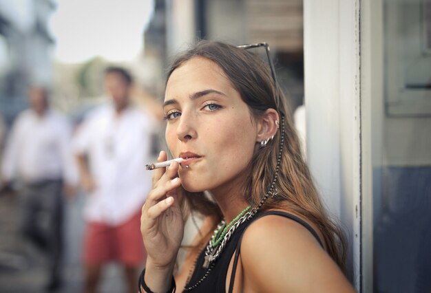 Portrait of a young female smoking in the street