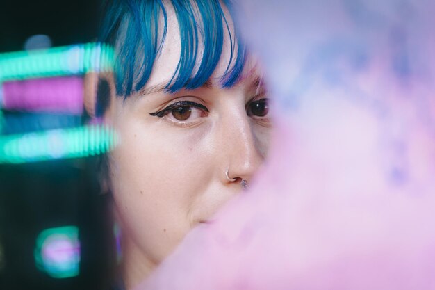 Portrait of a young female with pink and blue hair with a serious facial expression