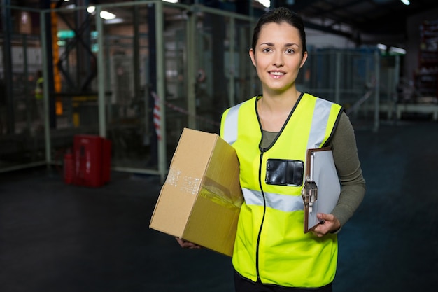 Free photo portrait of young female worker standing in warehouse