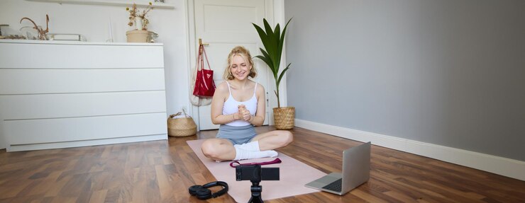 Free Photo portrait of young fitness blogger woman showing exercises to her followers recording video on