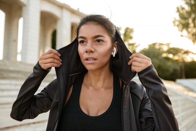 Portrait of a young fitness woman in earphones