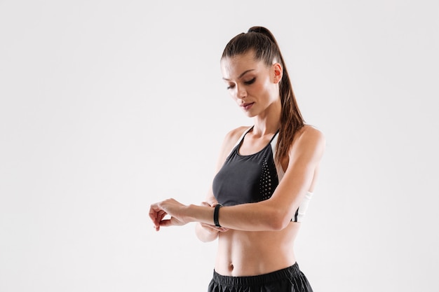 Portrait of a young fitness woman looking at her wrist watch